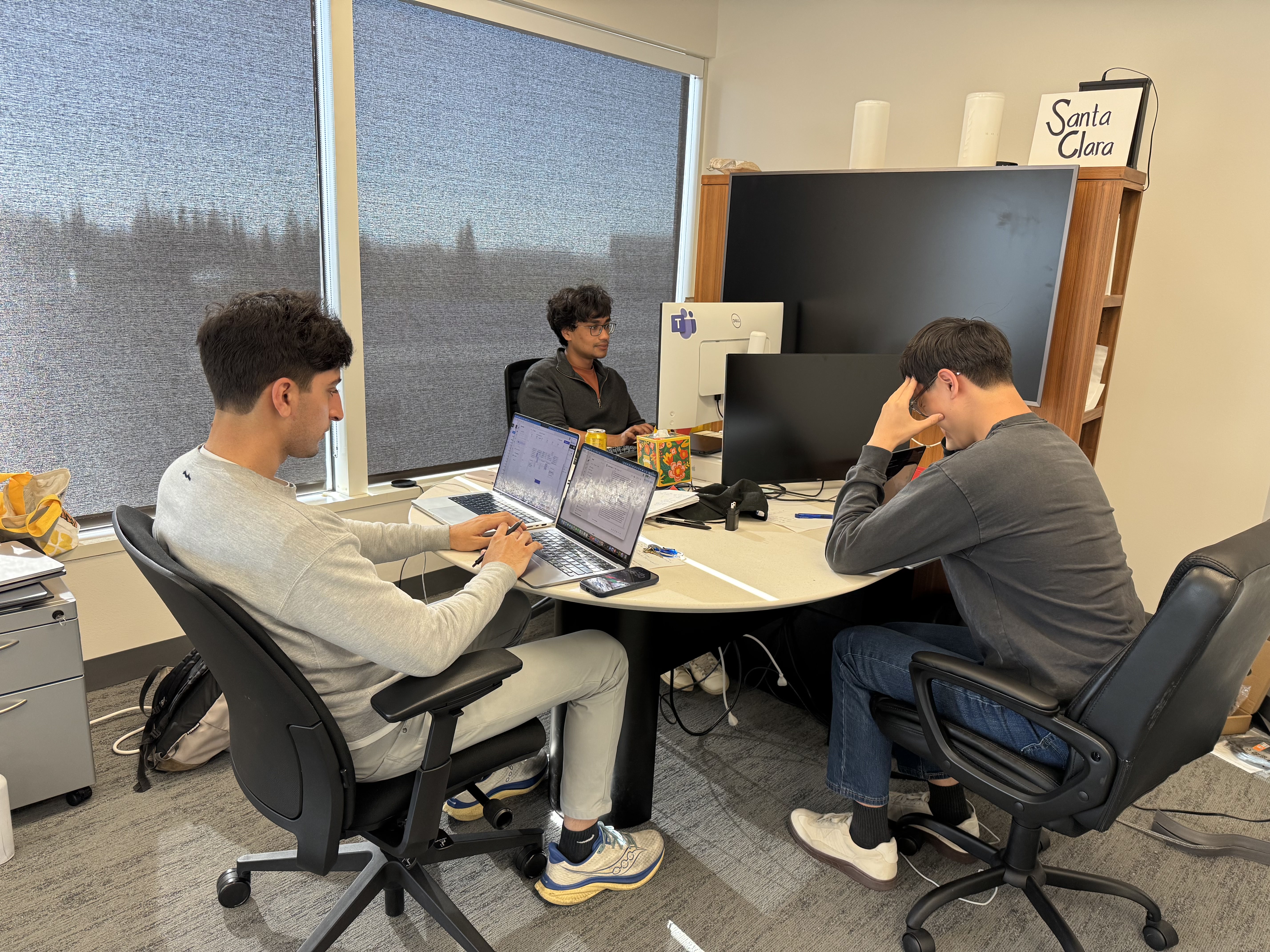 Engineers at their desks in front of the Santa Clara sign